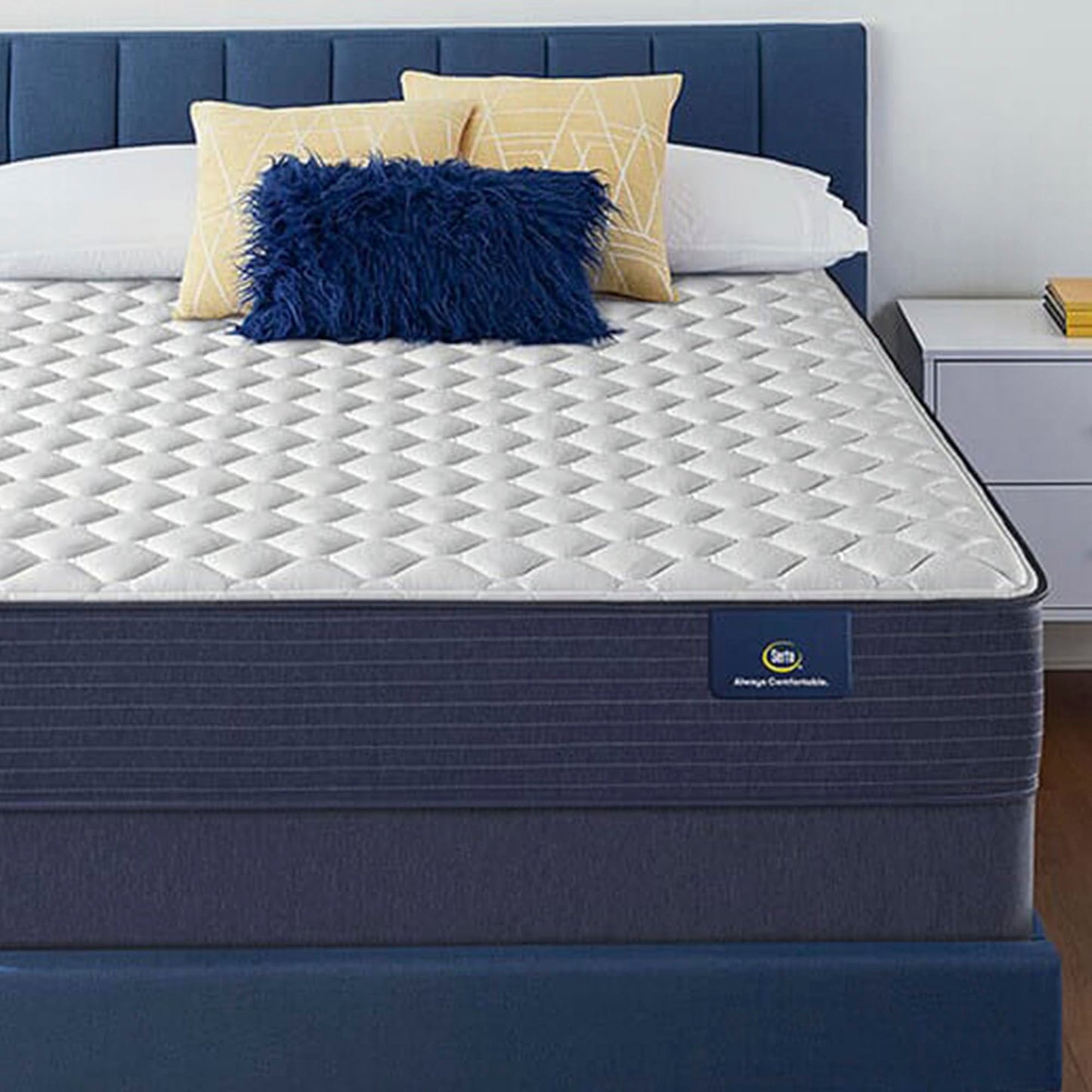 The Serta Classic Firm 10.5" in a bedroom on a blue bed