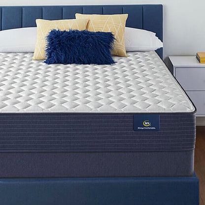 The Serta Classic Firm 10.5" in a bedroom on a blue bed