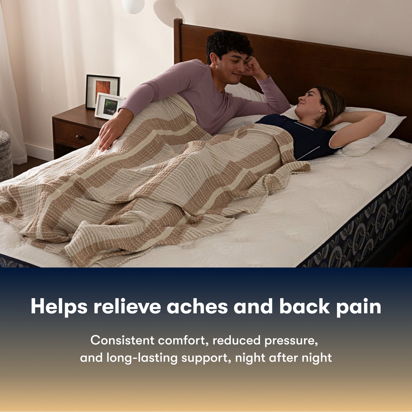 Couple lying in bed on a Serta pefect sleeper hybrid plush mattress under a striped blanket with text about back pain relief.