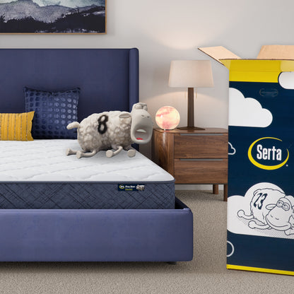 8 inch medium mattress in a blue bedframe with a Serta sheep with a number on top of it with the Serta packaging to the right of the bed