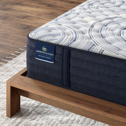 Corner of Perfect Sleeper Pro Hampton Extra Firm mattress sitting in a brown bedframe || level: Level 1 || feel: Extra Firm
