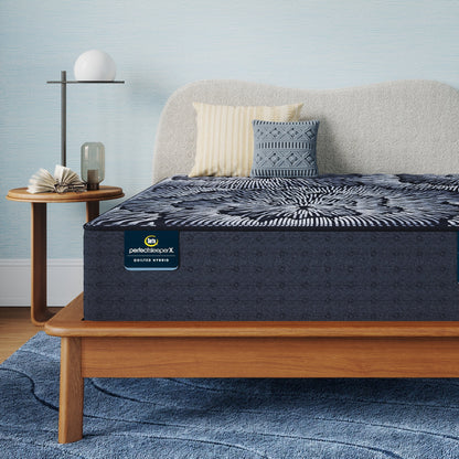Perfect Sleeper X Quilted Hybrid Excelled Extra Firm Mattress sitting in a brown bedframe || feel: Extra Firm || level: Level 1