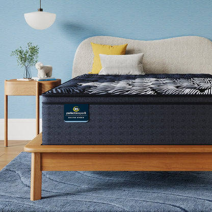 Perfect Sleeper X Quilted Hybrid Max Firm Pillow Top Mattress sitting in a brown bedframe || feel: Firm Pillow Top || level: Level 2