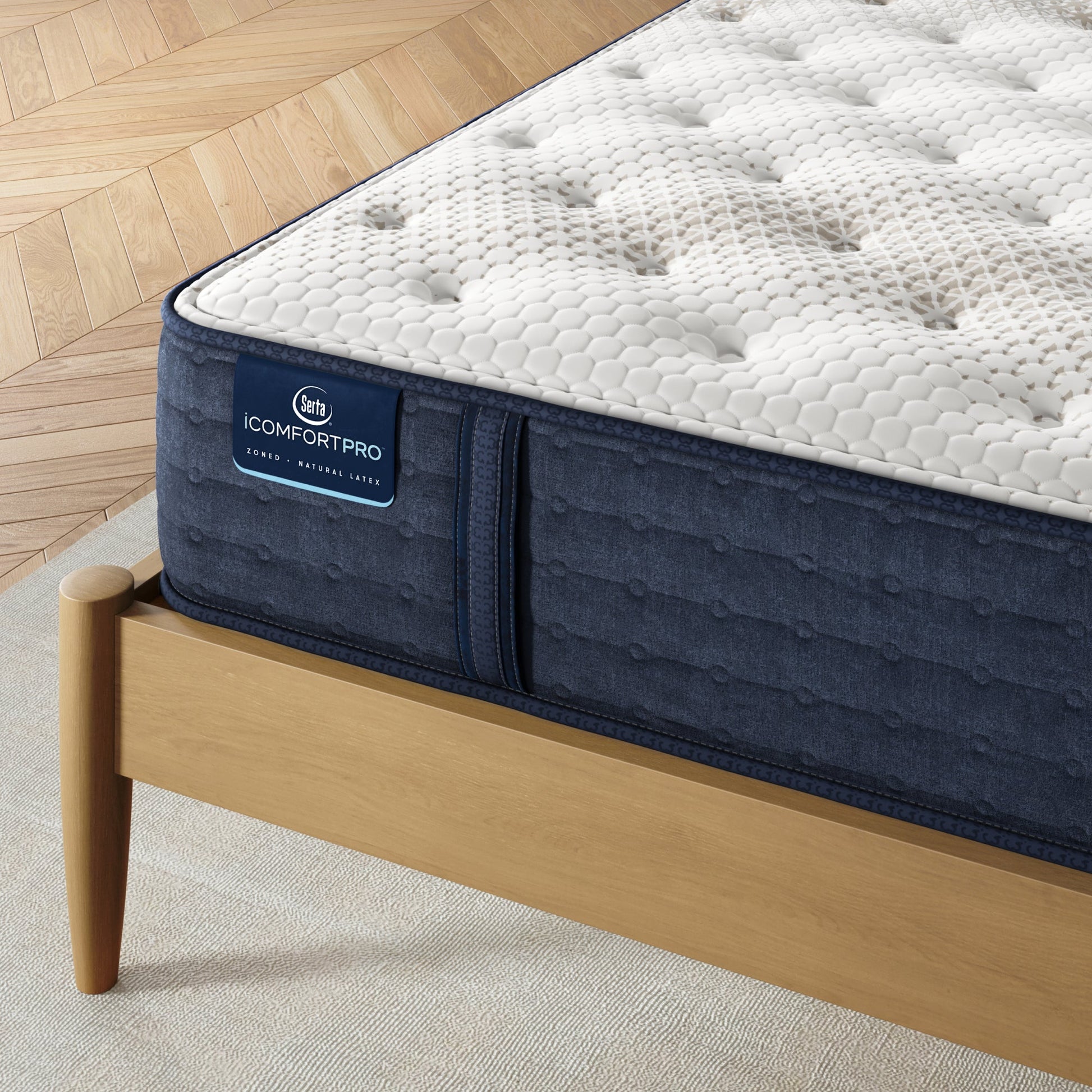 Corner of iComfortPro Chelsea Extra Firm Mattress sitting in a brown bedframe || feel: extra firm || level: Level 1
