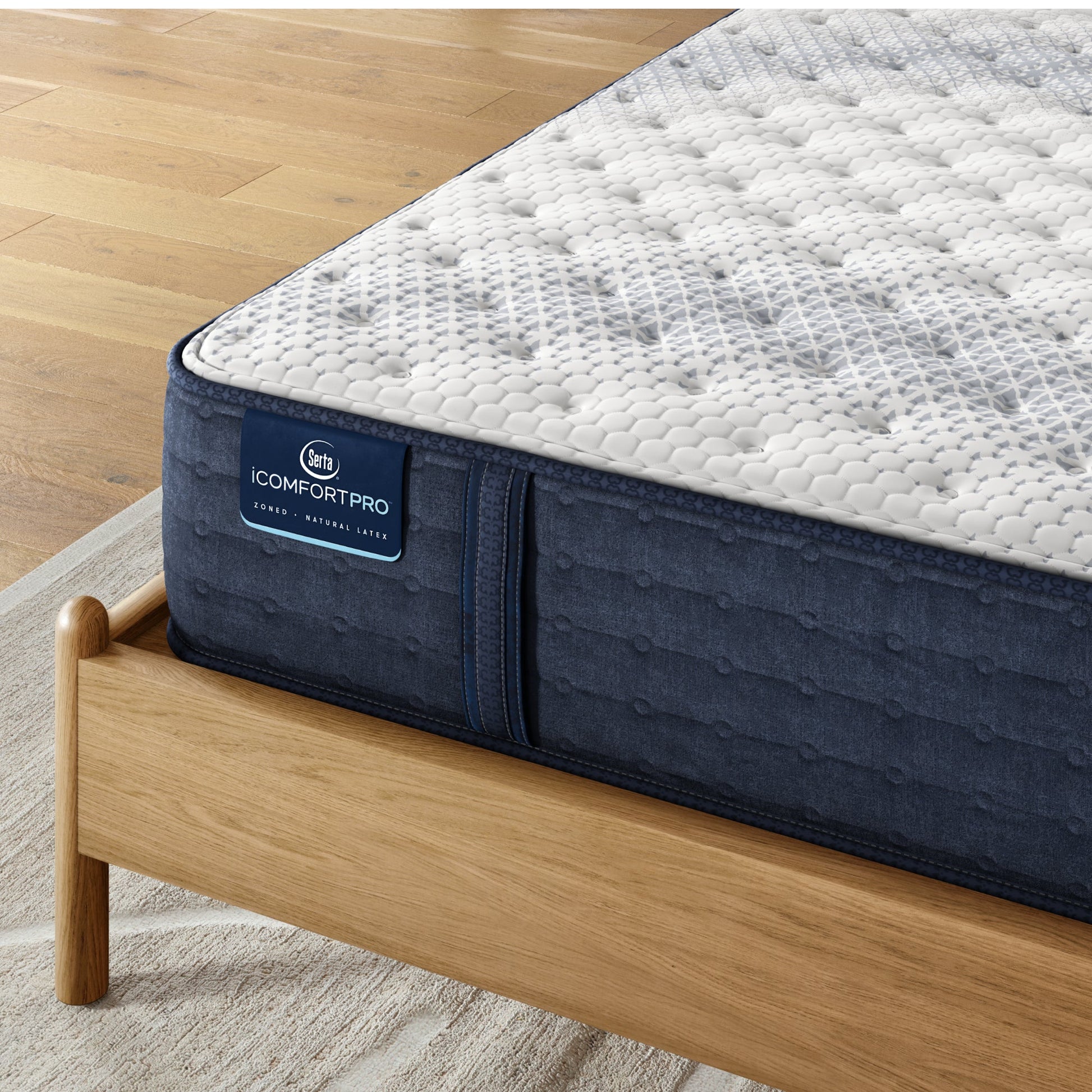 Corner of iComfortPro Ambrose Firm Mattress sitting in a brown bedframe || feel: firm || level: Level 2