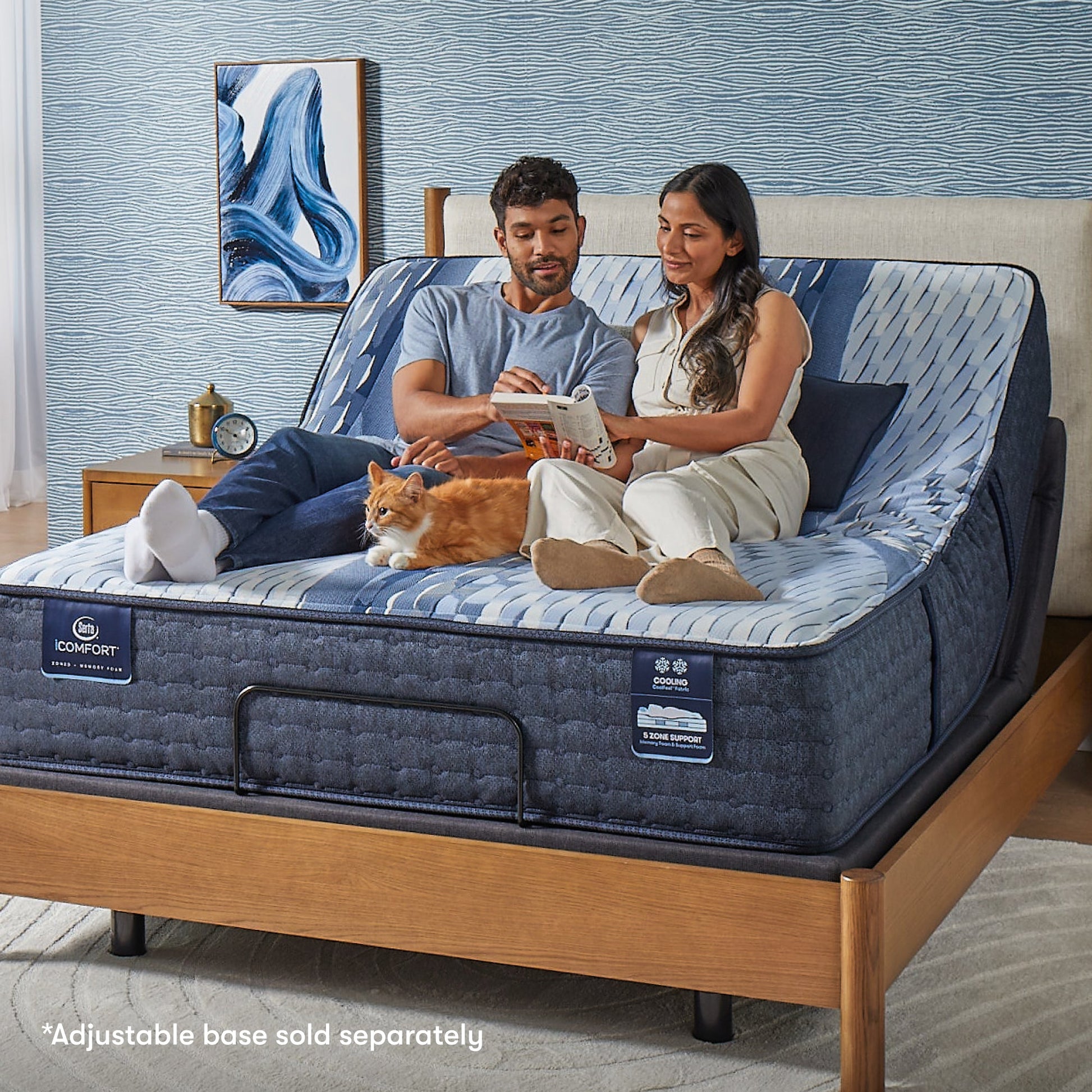 Woman and man sitting on a Serta iComfort mattress with a cat by their feet in between them reading a crossword puzzle || feel: medium || level: Standard - 13"