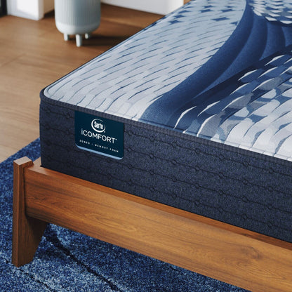 Corner of a iComfort Elana Firm Mattress sitting in a brown bedframe || feel: firm || level: Standard - 11.5"