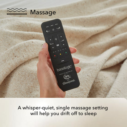 Hand holding a black remote control with 'baselogic' branding against a beige fabric background.