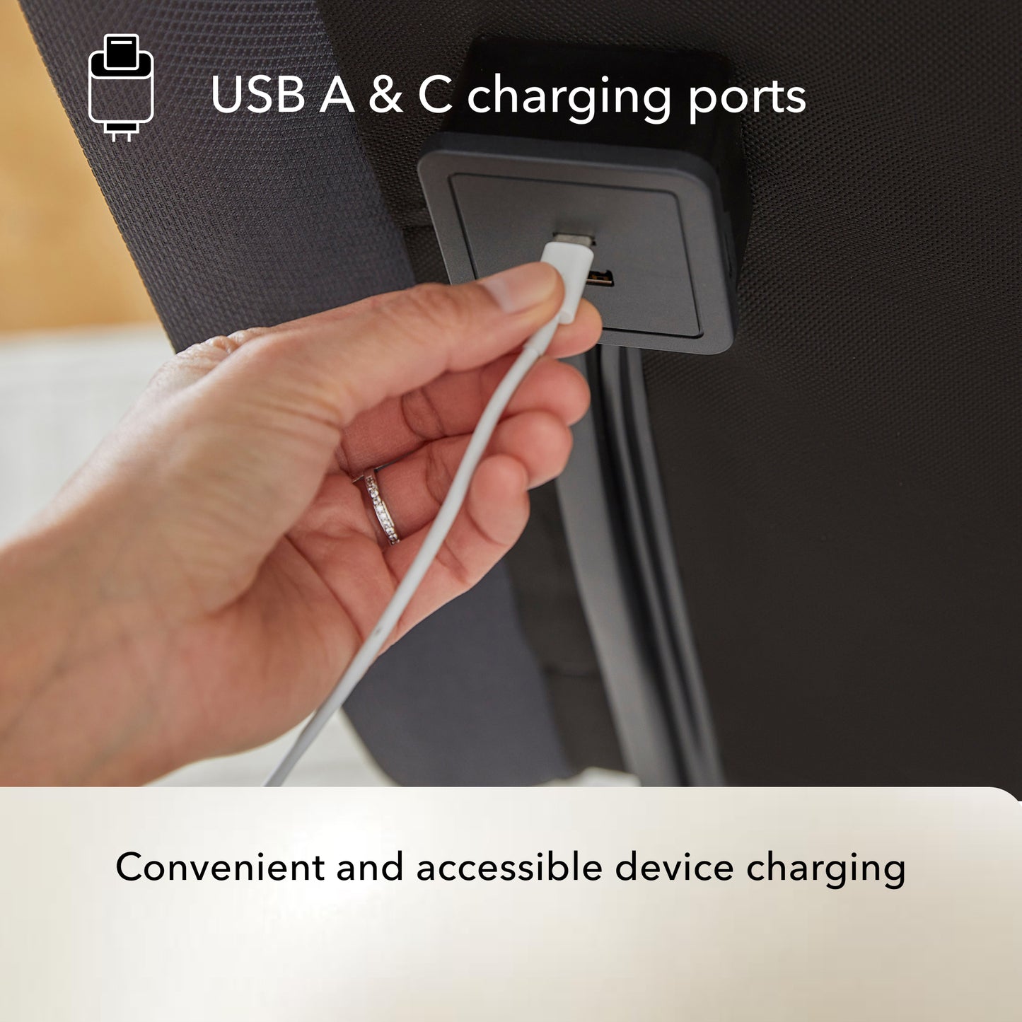 Hand plugging a USB cable into a Baselogic Pearl adjustable base USB A & C charging port.