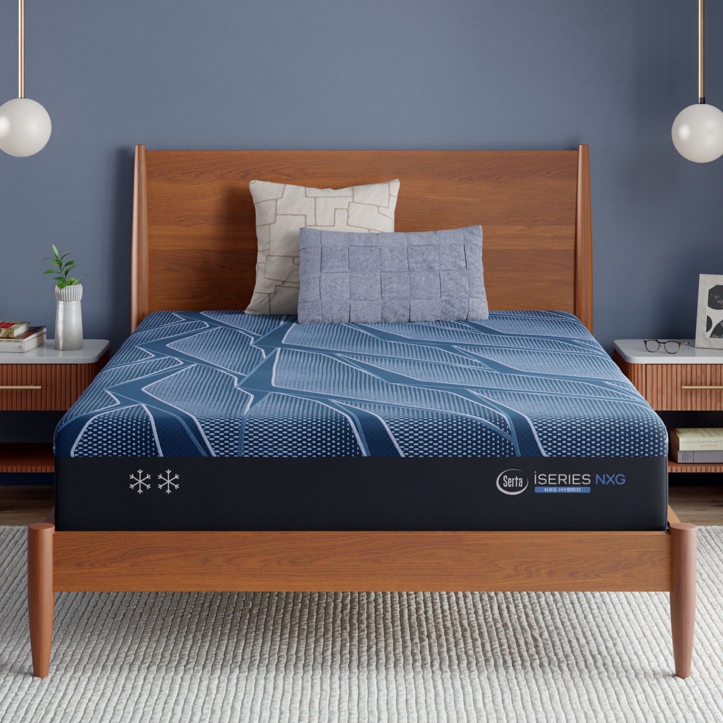 Blue iSeries® NXG Hybrid mattress with a brand logo on a wooden bed frame against a blue wall.