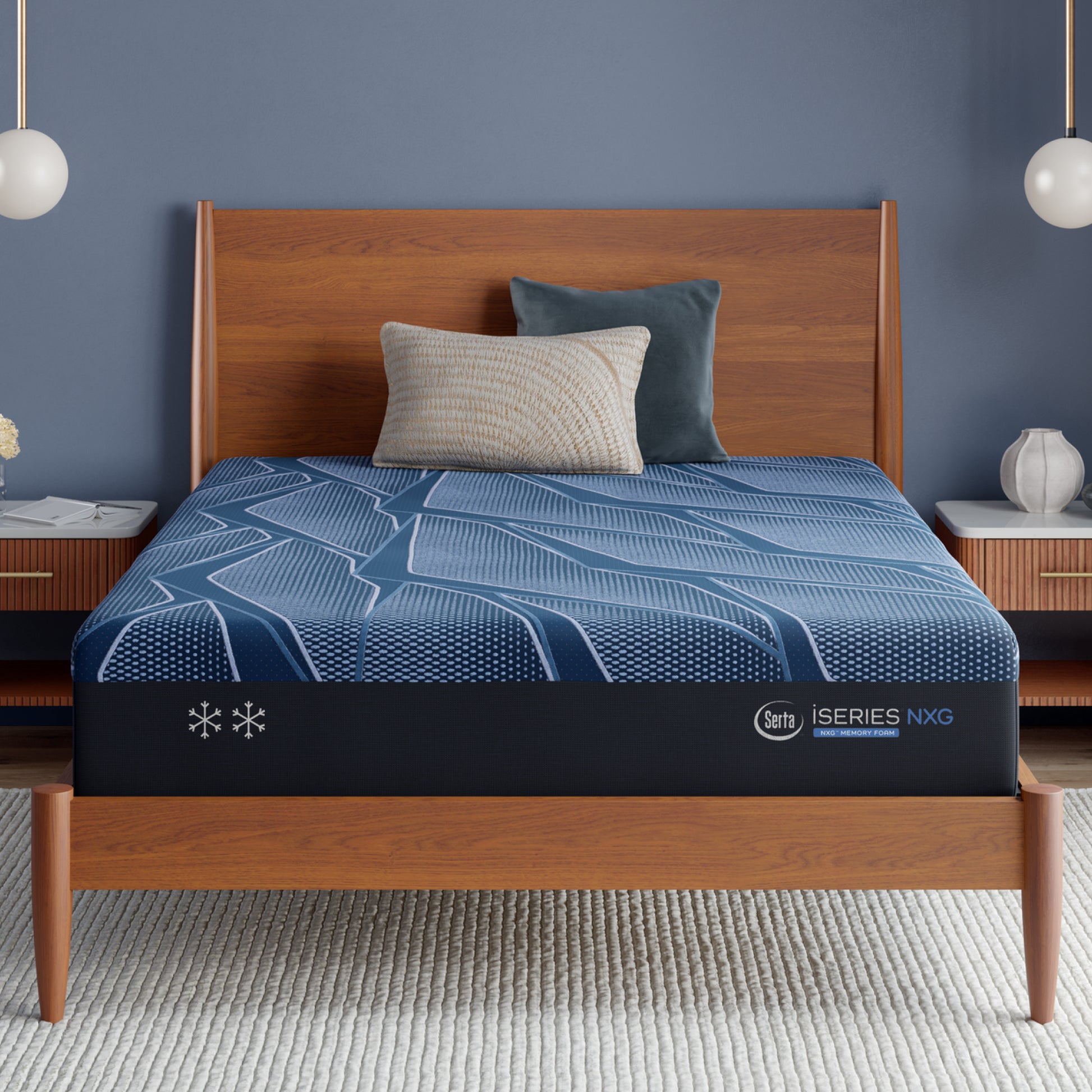 Blue Serta iSeries NXG mattress on a wooden bed frame with a dark blue wall and white pendant lights.