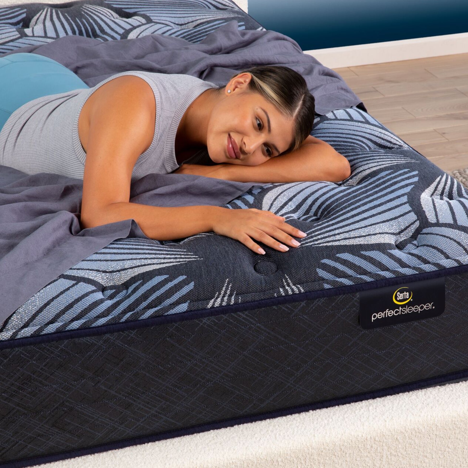 A woman laying in a bedroom on the Serta Perfect Sleeper Sleep Excellence mattress | feel: Extra Firm