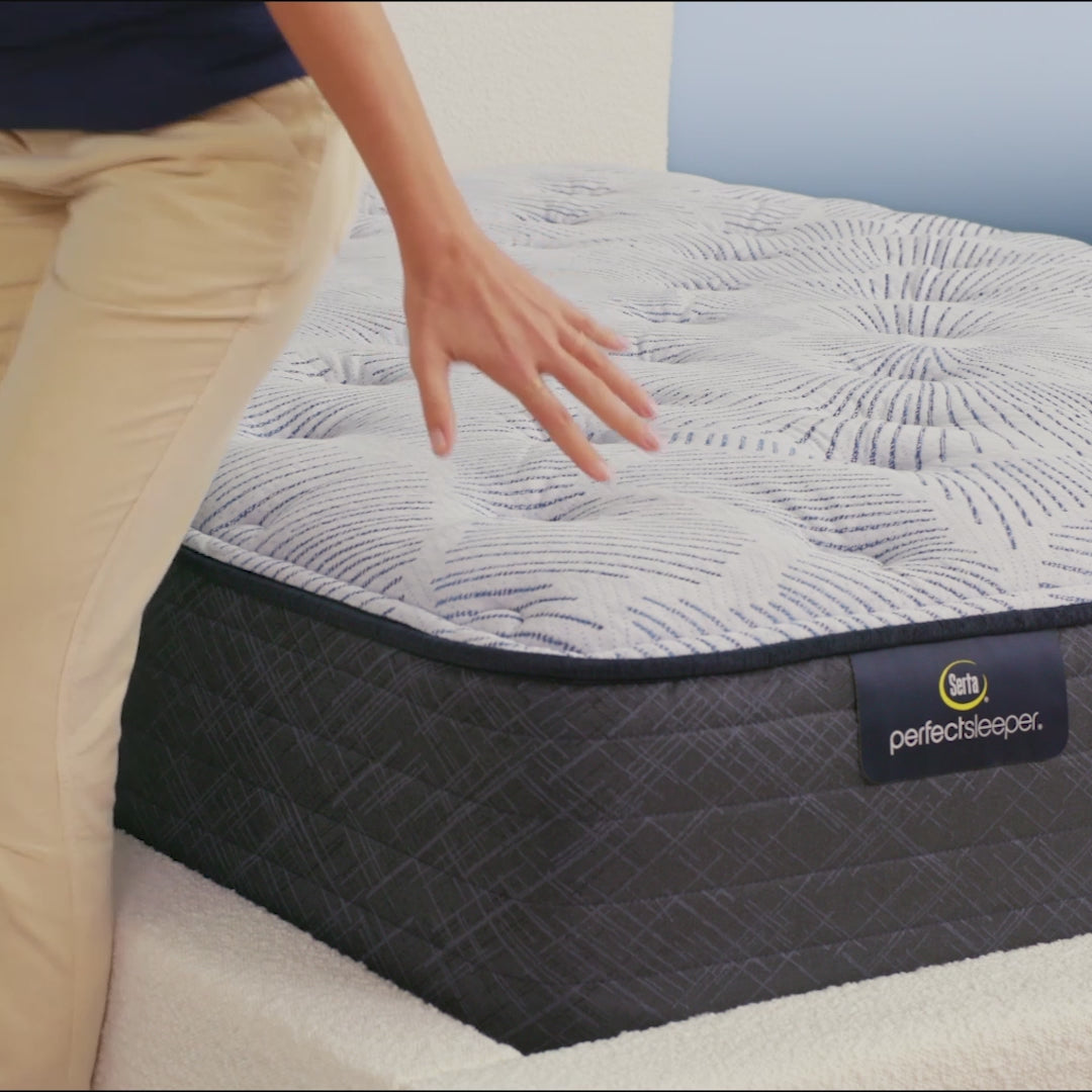 Person sitting on bed to show firmness level of Serta Perfect Sleeper plush mattress||feel: plush||level: enhanced