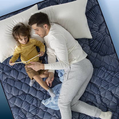 Dad and son reading in bed on a Serta Perfect Sleeper mattress||feel: extra firm||level: ultimate